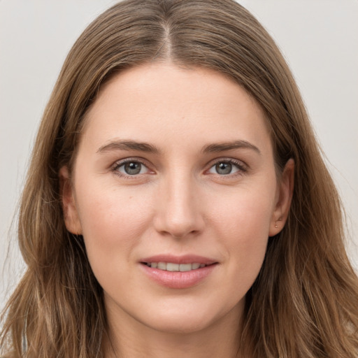 Joyful white young-adult female with long  brown hair and grey eyes