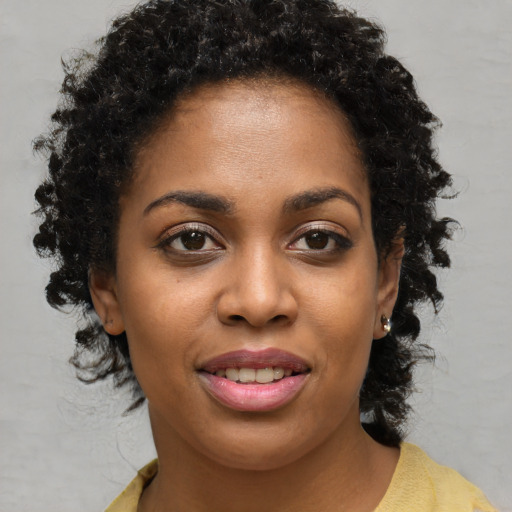 Joyful black young-adult female with medium  brown hair and brown eyes