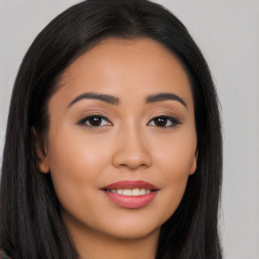 Joyful latino young-adult female with long  brown hair and brown eyes