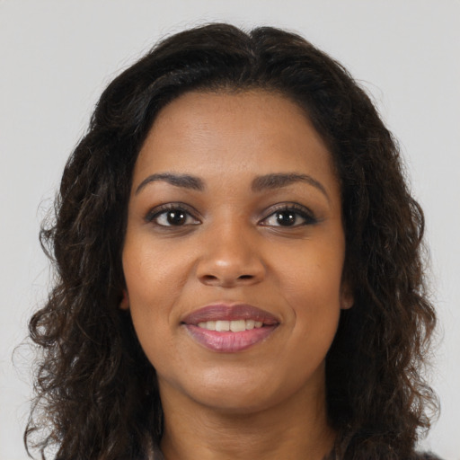 Joyful black young-adult female with long  brown hair and brown eyes
