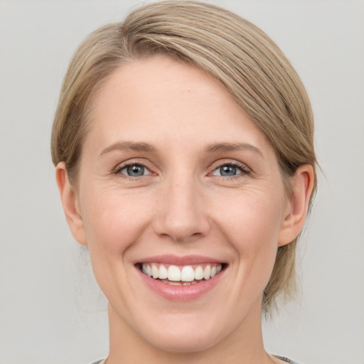 Joyful white young-adult female with medium  brown hair and blue eyes