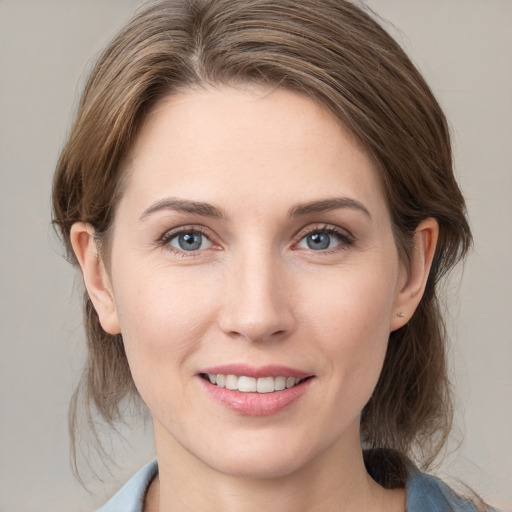 Joyful white young-adult female with medium  brown hair and grey eyes