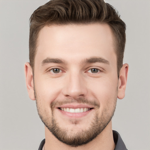 Joyful white young-adult male with short  brown hair and grey eyes