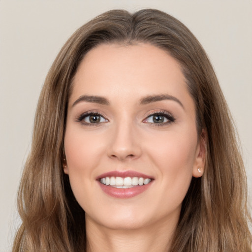 Joyful white young-adult female with long  brown hair and brown eyes