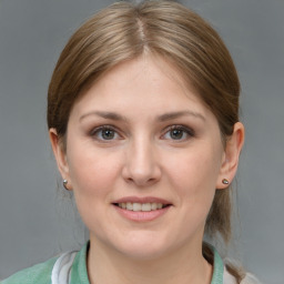 Joyful white young-adult female with medium  brown hair and grey eyes