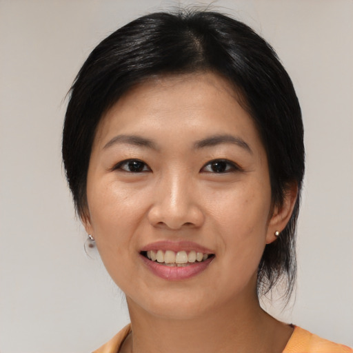 Joyful asian young-adult female with medium  black hair and brown eyes