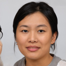 Joyful asian young-adult female with medium  brown hair and brown eyes