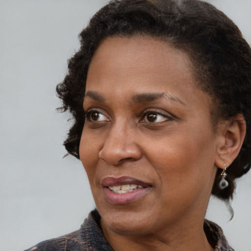 Joyful black adult female with short  brown hair and brown eyes