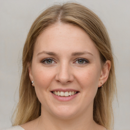 Joyful white young-adult female with medium  brown hair and grey eyes