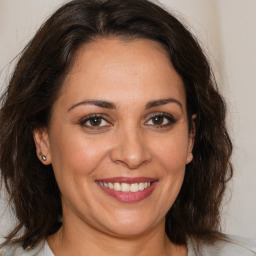 Joyful white adult female with medium  brown hair and brown eyes