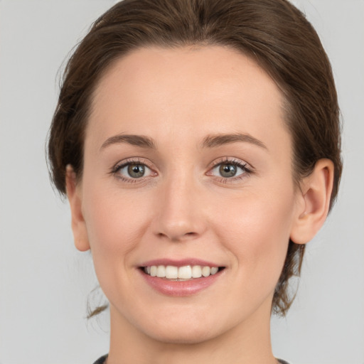 Joyful white young-adult female with medium  brown hair and green eyes