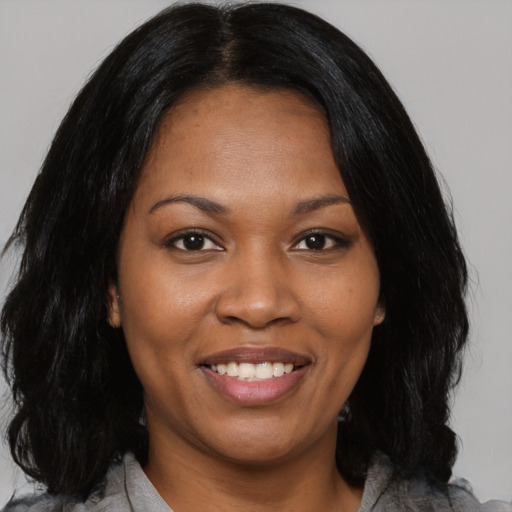 Joyful black young-adult female with medium  black hair and brown eyes