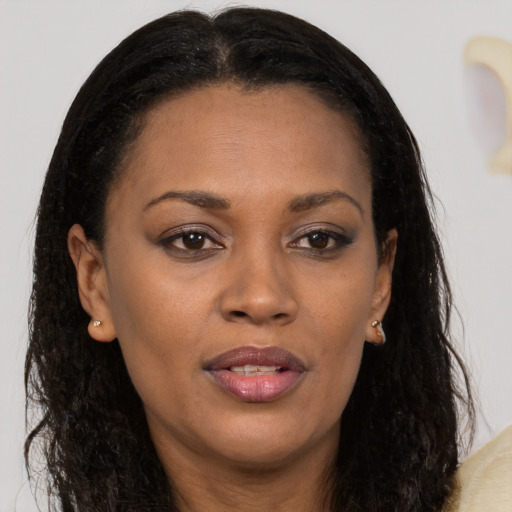 Joyful black young-adult female with long  brown hair and brown eyes
