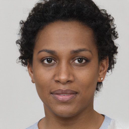 Joyful black young-adult female with short  brown hair and brown eyes