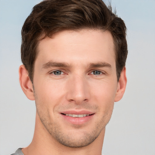 Joyful white young-adult male with short  brown hair and grey eyes