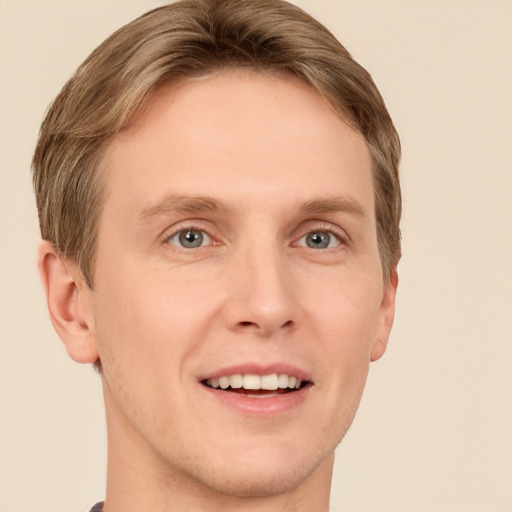 Joyful white young-adult male with short  brown hair and grey eyes