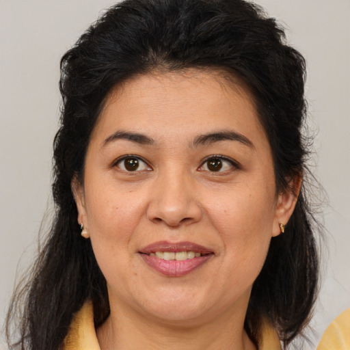 Joyful latino adult female with medium  brown hair and brown eyes