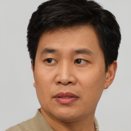 Joyful asian adult male with short  black hair and brown eyes