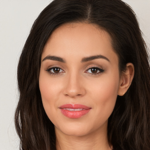 Joyful white young-adult female with long  brown hair and brown eyes