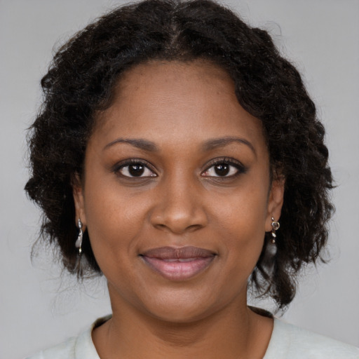 Joyful black young-adult female with medium  brown hair and brown eyes
