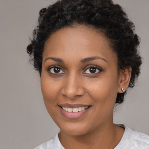 Joyful black young-adult female with short  brown hair and brown eyes