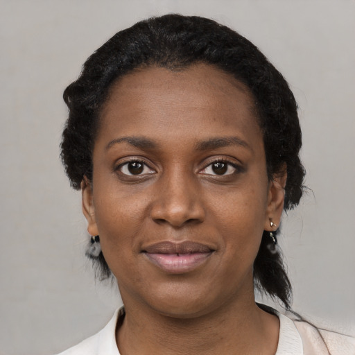 Joyful black young-adult female with short  black hair and brown eyes