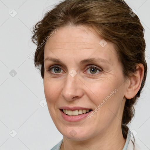 Joyful white adult female with medium  brown hair and green eyes