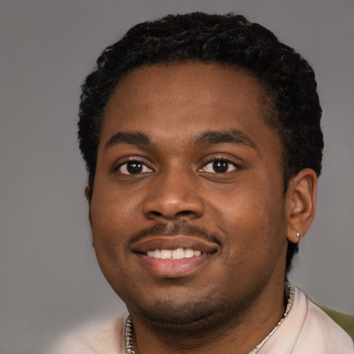 Joyful black young-adult male with short  black hair and brown eyes