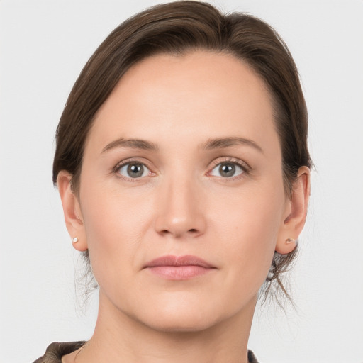 Joyful white young-adult female with medium  brown hair and grey eyes