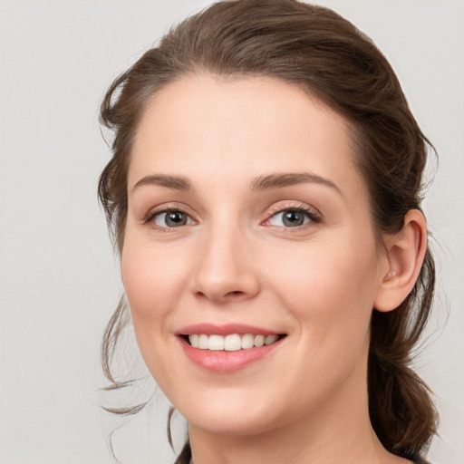 Joyful white young-adult female with medium  brown hair and blue eyes