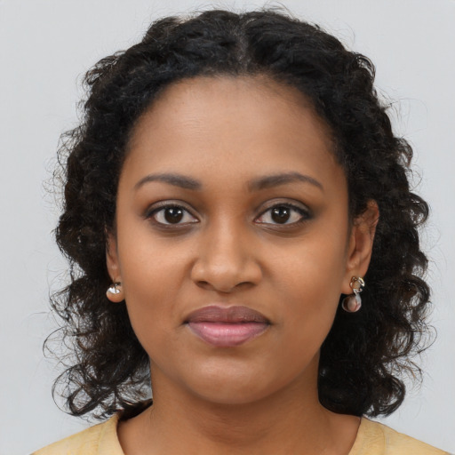 Joyful black young-adult female with long  brown hair and brown eyes