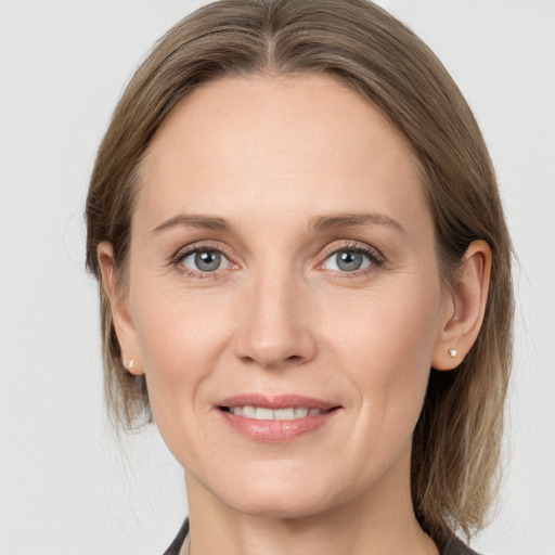 Joyful white adult female with medium  brown hair and grey eyes