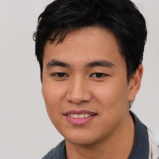 Joyful asian young-adult male with short  black hair and brown eyes