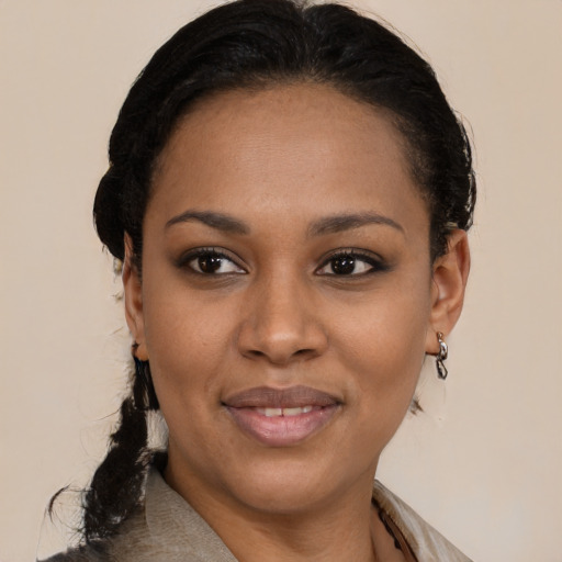 Joyful black young-adult female with long  black hair and brown eyes