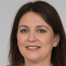 Joyful white adult female with long  brown hair and brown eyes