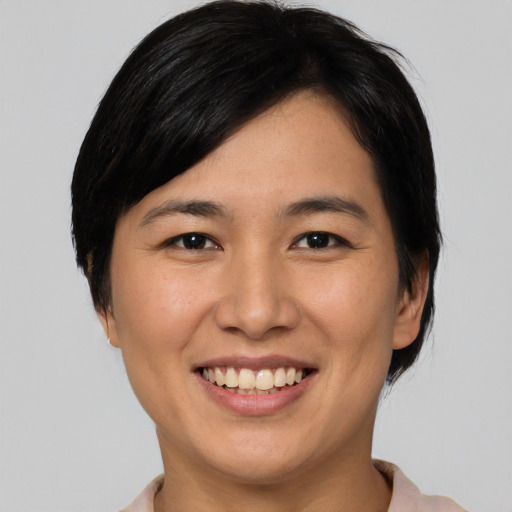 Joyful asian young-adult female with medium  black hair and brown eyes