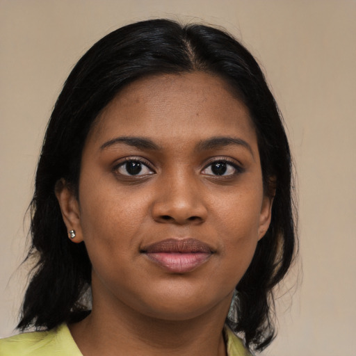Joyful black young-adult female with medium  black hair and brown eyes