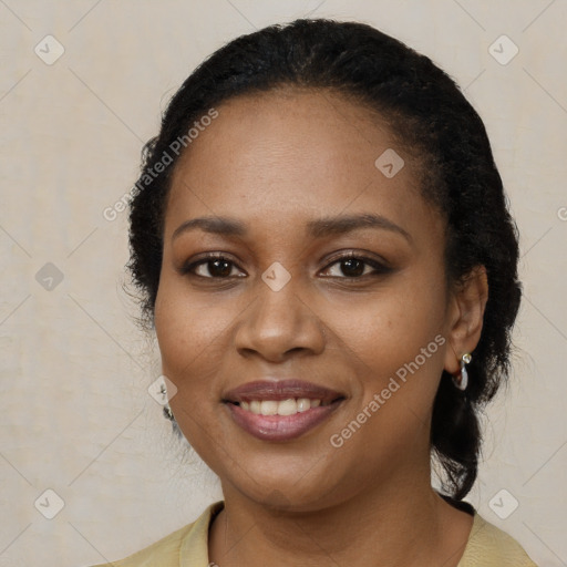 Joyful black young-adult female with long  black hair and brown eyes