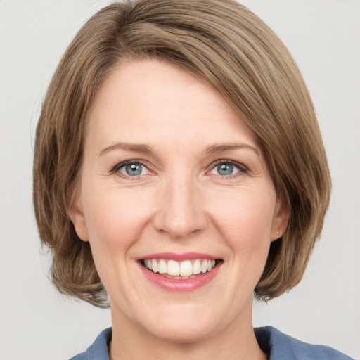 Joyful white adult female with medium  brown hair and grey eyes