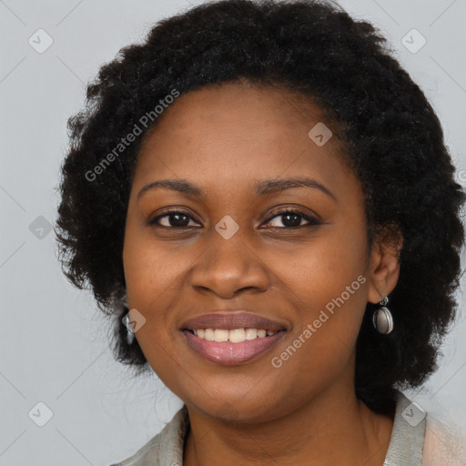 Joyful black young-adult female with long  black hair and brown eyes