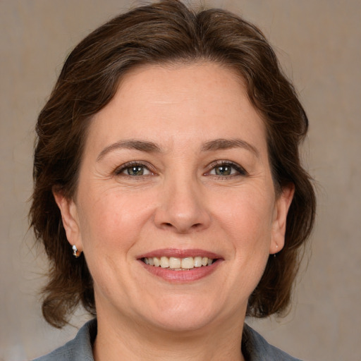 Joyful white adult female with medium  brown hair and brown eyes