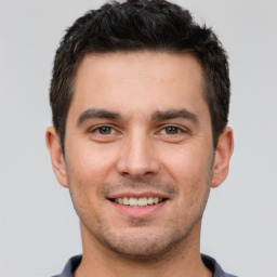 Joyful white young-adult male with short  brown hair and brown eyes