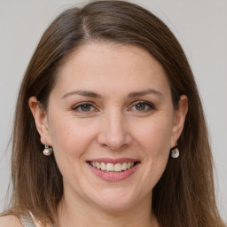 Joyful white adult female with long  brown hair and grey eyes