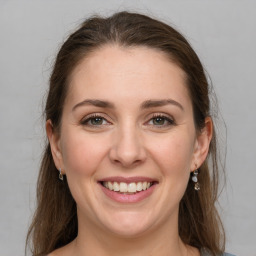 Joyful white young-adult female with medium  brown hair and grey eyes