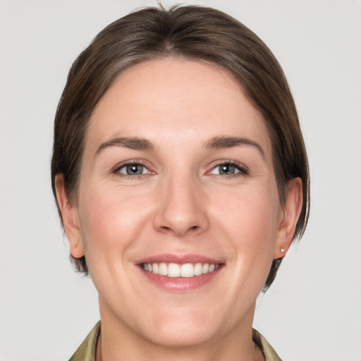 Joyful white young-adult female with short  brown hair and grey eyes