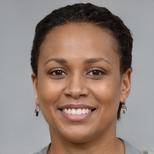 Joyful latino young-adult female with short  brown hair and brown eyes
