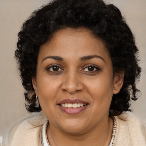 Joyful black young-adult female with long  brown hair and brown eyes