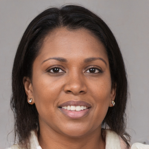 Joyful black young-adult female with medium  brown hair and brown eyes