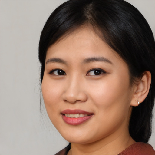 Joyful asian young-adult female with medium  brown hair and brown eyes