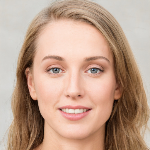 Joyful white young-adult female with long  brown hair and blue eyes